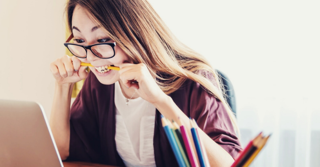 woman biting pencil stressed