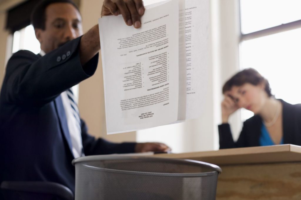 man throwing resume into trash can